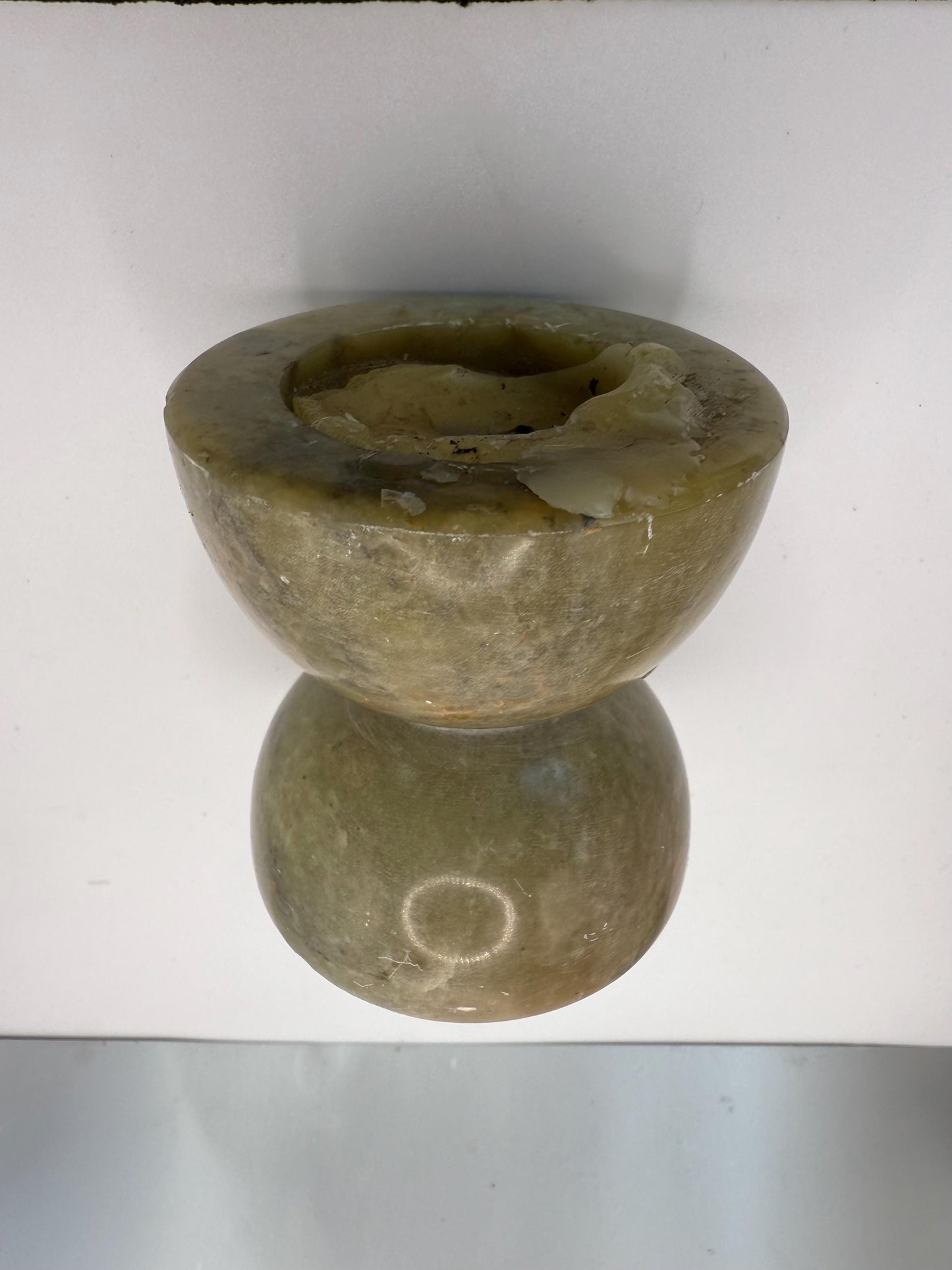 A green soap stone candle holder hand made in India