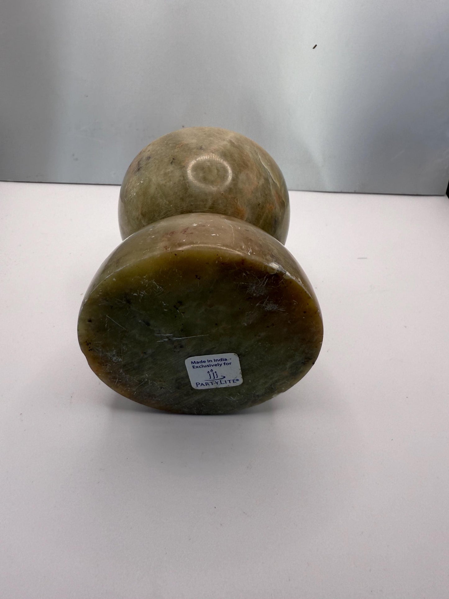 A green soap stone candle holder hand made in India